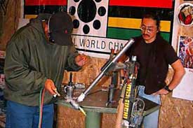 Koichi Yamaguchi watches over as a student brazes the seat tube to bottom bracket.